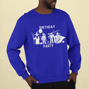 A man wearing a royal blue crewneck sweatshirt with a simplistically drawn wizard holding a balloon, ranger with a party hat, barbarian yelling "Happy Birthday" and knight with a party blower. Cake and gifts around them. It says Birthday Party.